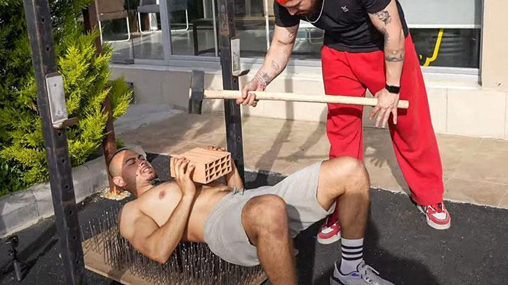 Arkadaşlarıyla iddiaya girdi, 700 çivinin üzrerine yatarak 100 kiloluk ağırlık kaldırdı